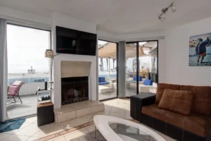 The living area opens seamlessly to the patio through large glass windows.