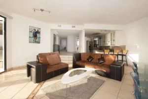 The spacious dining area features a low-maintenance glass-top table.