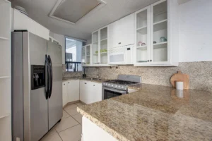Fully equipped kitchen with granite countertops, wood and glass cabinetry.