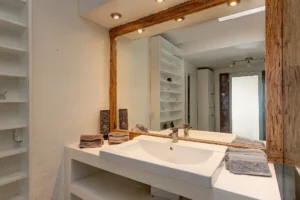 Wood-framed vanity, and recessed lighting.