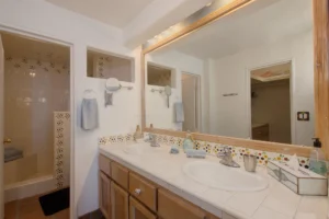 The bathroom features a large, full-length vanity mirror that enhances light and space.