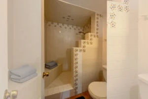The step-in shower features matching Mexican tile and a built-in tiled seat.