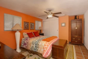 With a built-in closet, ceiling fan, and wood furniture.