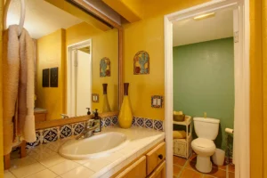 The second bathroom is also vibrant, featuring cheerful yellow and summer-green tones