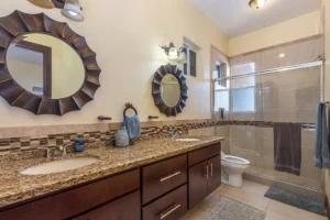 The luxurious en-suite bathroom includes dual vanities and an elegant shower